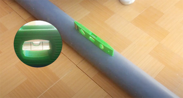 Dùng thước thủy để đo độ cân bằng của ống nối khi đặt trên mặt phẳng